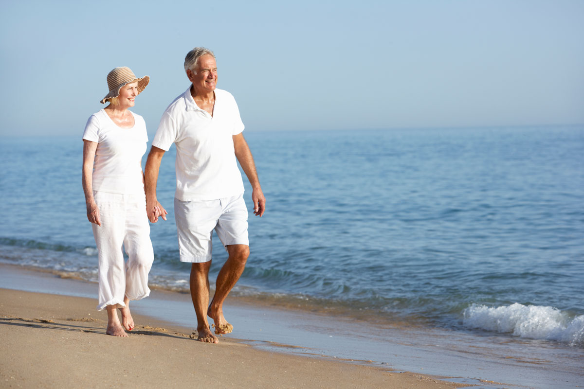 retired-couple-walking-on-beach