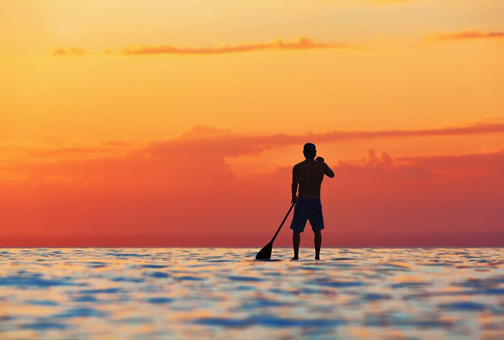 stand up paddle boarding at sunset