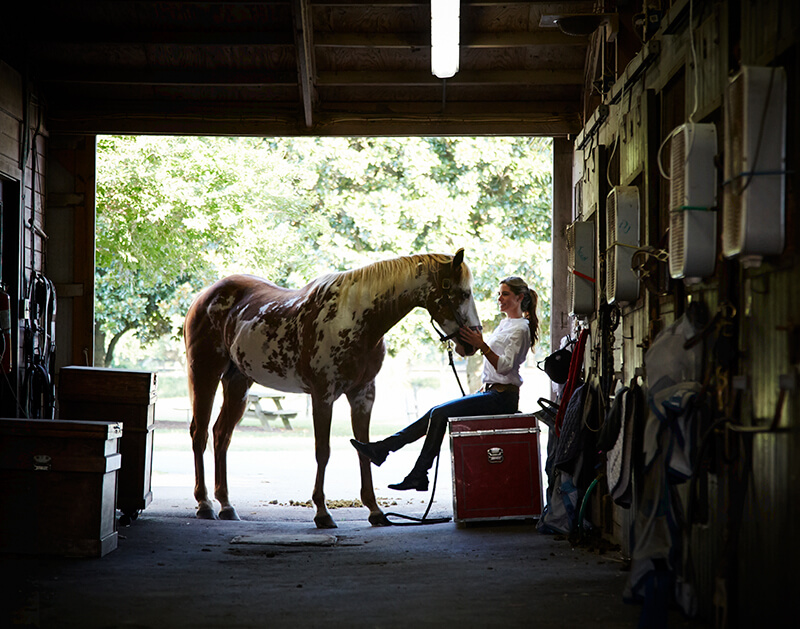 woman with horse in Seabrook Island equestrian center stall