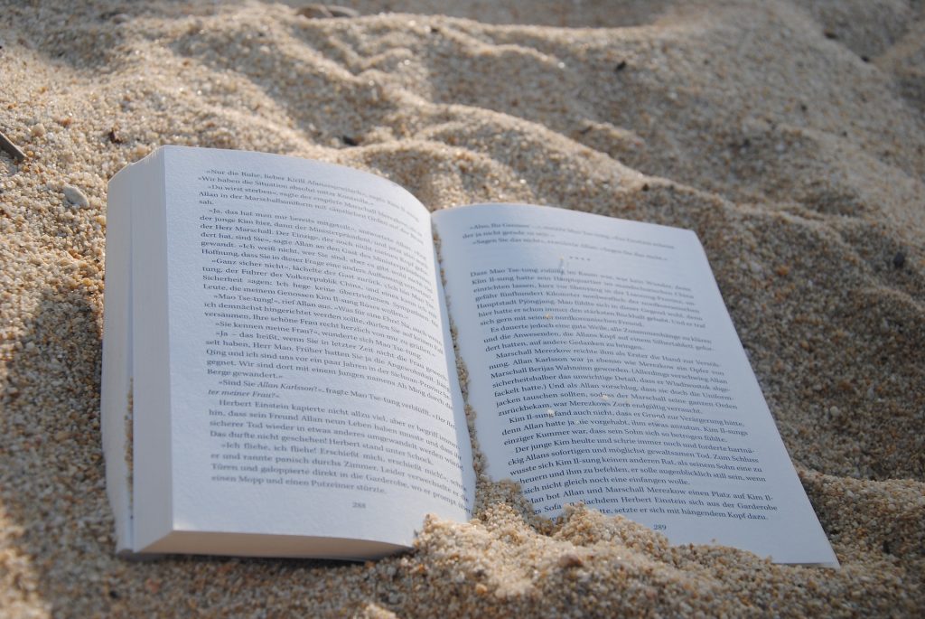 open book sitting in the sand