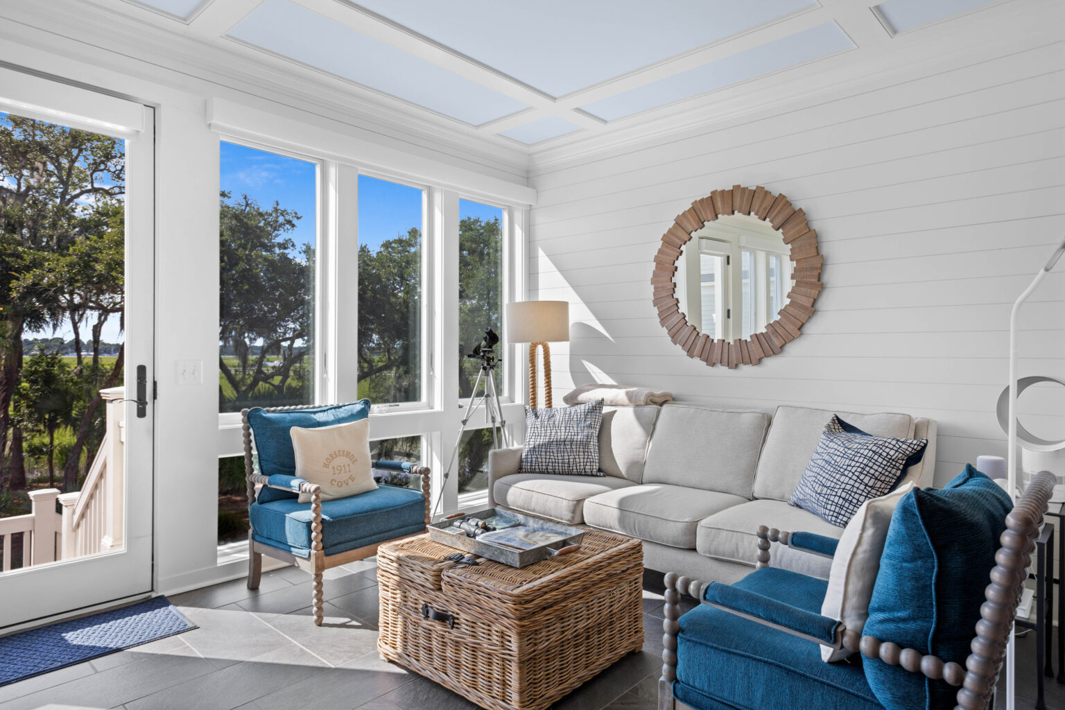 Bright and inviting coastal living room with large windows, natural light, and modern coastal décor that enhances a home’s curb appeal and welcoming atmosphere.